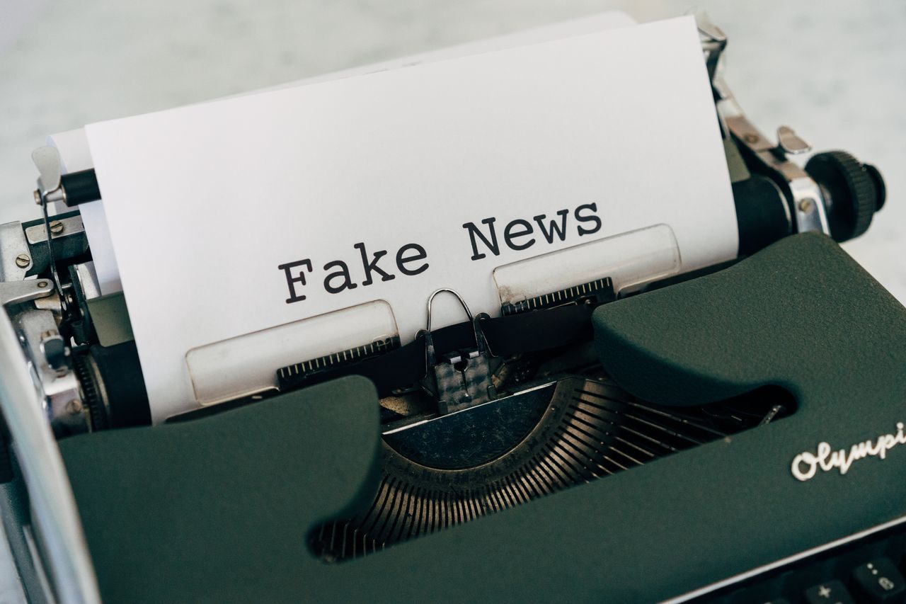 why-choose-us Close-up of vintage typewriter printing Fake News, depicting false information concepts.